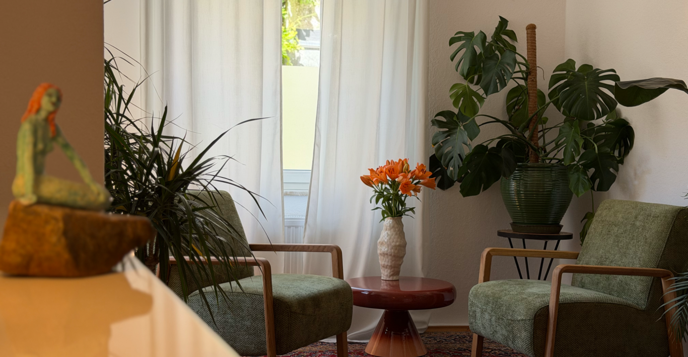 Blick in die Praxis für Psychotherapie von Silja Wübbelmann in Heidelberg Sitzecke mit Pflanzen und einem Blumenstrauß auf dem Tisch.